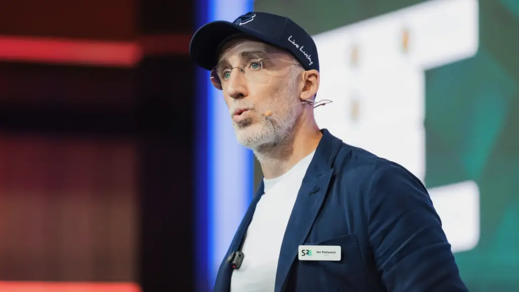 Uri Poliavich jitkellem fuq il-palk f'konferenza tal-industrija bħala CEO
